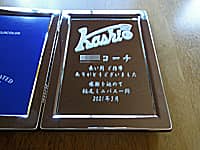 卒団生からコーチへ贈る写真立て(チームのマークと、○○コーチ 長い間ご指導ありがとうございました 感謝を込めて ○○一同を、ブックタイプの写真立ての鏡部に彫刻)