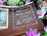 「校章、感謝を込めて、○○先生、○年度卒業○○中学校4組一同」を彫刻した、恩師への贈り物用のガラス製写真立て