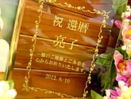 「祝還暦、名前、日付」を彫刻した、還暦祝い用のガラス製フォトスタンド