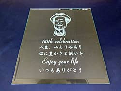 お祝いメッセージとお父さんの似顔絵を彫刻した、父親への還暦祝い用のガラス盾