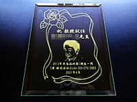 教授就任祝い用のガラス盾(先生の似顔絵と、祝教授就任 ○○先生 ○○一同を、長方形のガラス盾に彫刻)