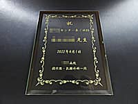 医療センター長就任祝い用のガラス盾(祝 ○○センター長ご就任 ○○先生 ○○病院消化器・乳腺外科一同を、長方形のガラス盾に彫刻)