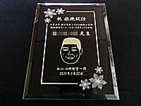 祝教授就任、先生の名前と似顔絵、就任日の日付、贈り主の名前を彫刻した、教授就任祝い用のガラス盾