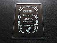 「還暦おめでとう これからも元気でいてね」を彫刻した、還暦祝い用のガラス盾
