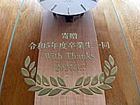 「寄贈 令和5年度卒業生一同、With Thanks、卒業式の日付」を前面ガラス部に彫刻した、卒業生から看護大学へ寄贈する壁掛け時計