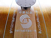 「卒業記念、校章、贈り主の名前」を前面ガラス部に彫刻した、卒業生から高校へ寄贈する壁掛け時計
