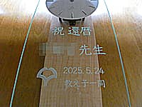 「祝還暦 ○○先生 教え子一同 大学のマーク」を前面ガラスに彫刻した、教授の還暦祝い用の壁掛け時計