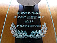 �u�j ��n��100���N�A��Ж��A���t�A�����̉�Ж��v��O�ʃK���X�ɒ��������A��Бn��100���N�j���p�̕Ǌ|�����v